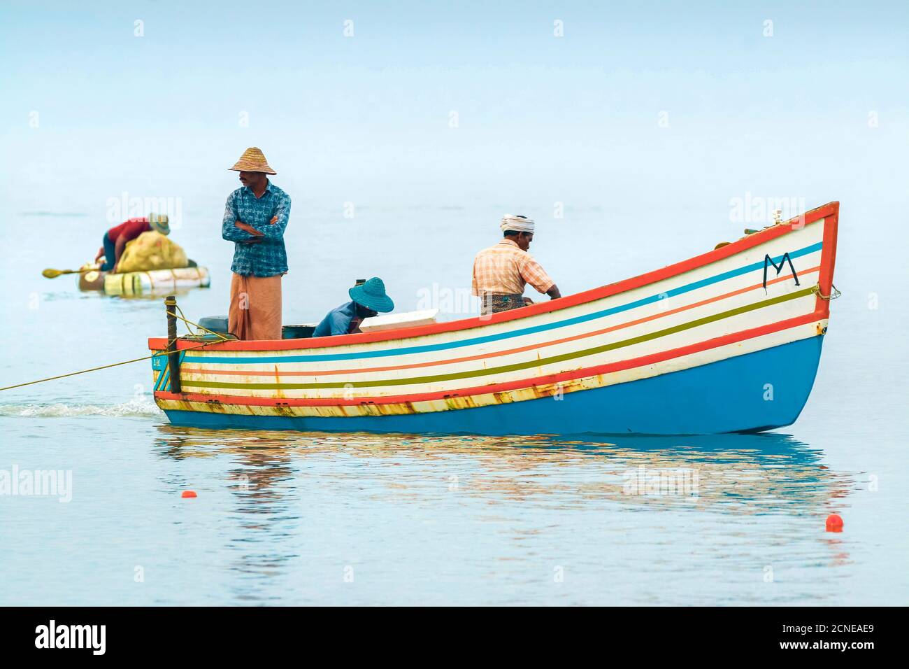Fischer in bunten Boot auf dem Arabischen Ozean direkt neben beliebten Marari Beach, Mararikulam, Alappuzha (Alleppey), Kerala, Indien, Asien Stockfoto