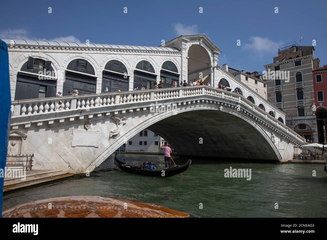 Gondoliere mit Touristen in Gondel unter der Rialtobrücke auf dem Grand Canal in Venedig, Italien, Europa. Stockfoto