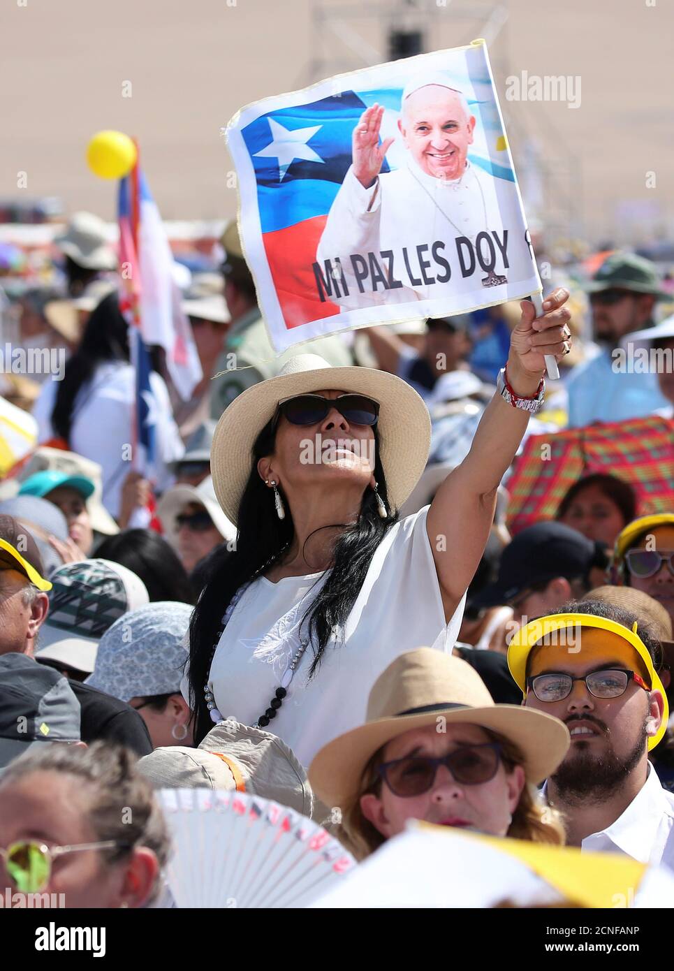 Eine Frau fliegt eine Flagge, als Papst Franziskus eintrifft, um eine Messe am Lobito-Strand in Iquique, Chile, zu führen, 18. Januar 2018. REUTERS/Alessandro Bianchi Stockfoto