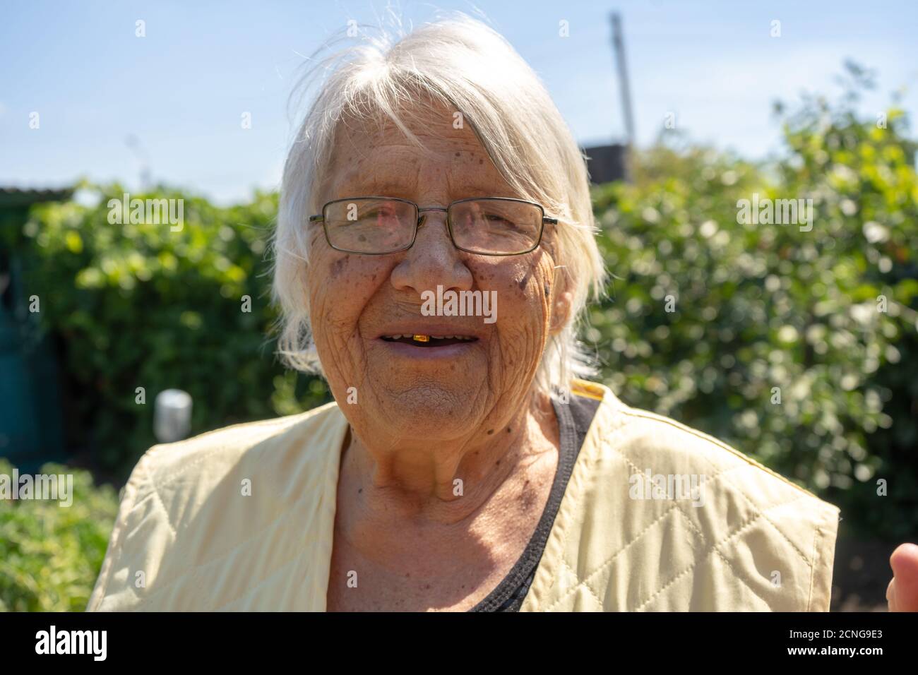 Alte Dame schönes Gesicht und graue Haare, ältere Frau in ihrem Garten, Großmutter lächelt aus der Nähe Stockfoto