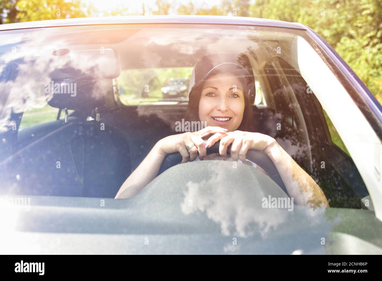 Schöne Erwachsene glückliche Frau trägt Hut fahren ihr Auto in Sommertag Stockfoto