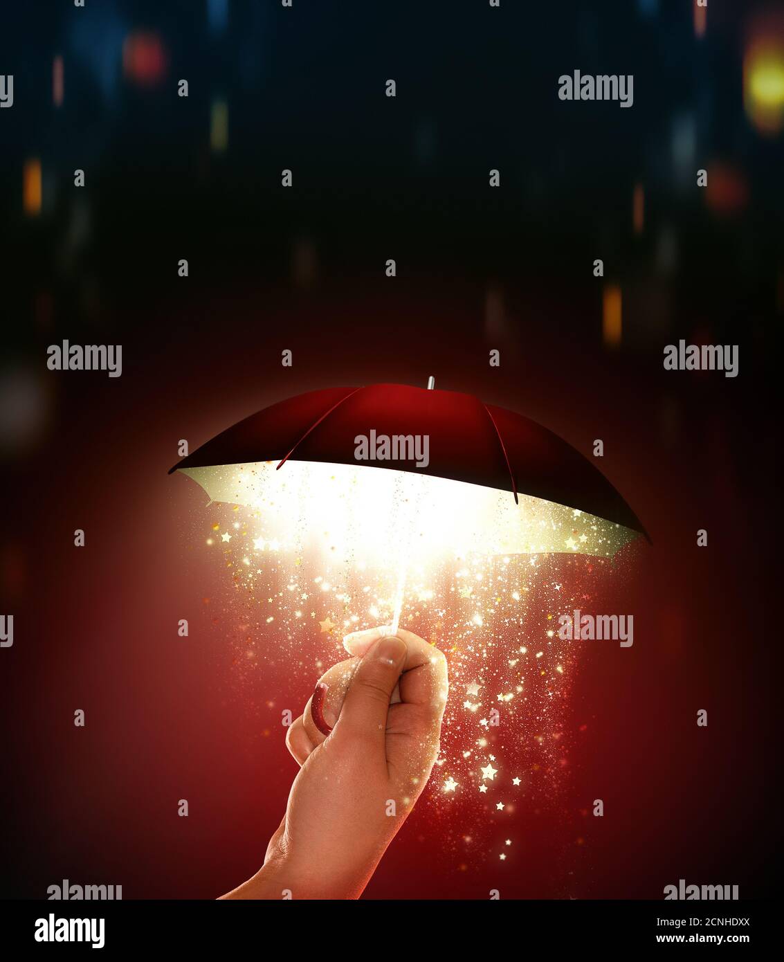 Hand hält einen Regenschirm mit einem magischen Glanz Stockfoto