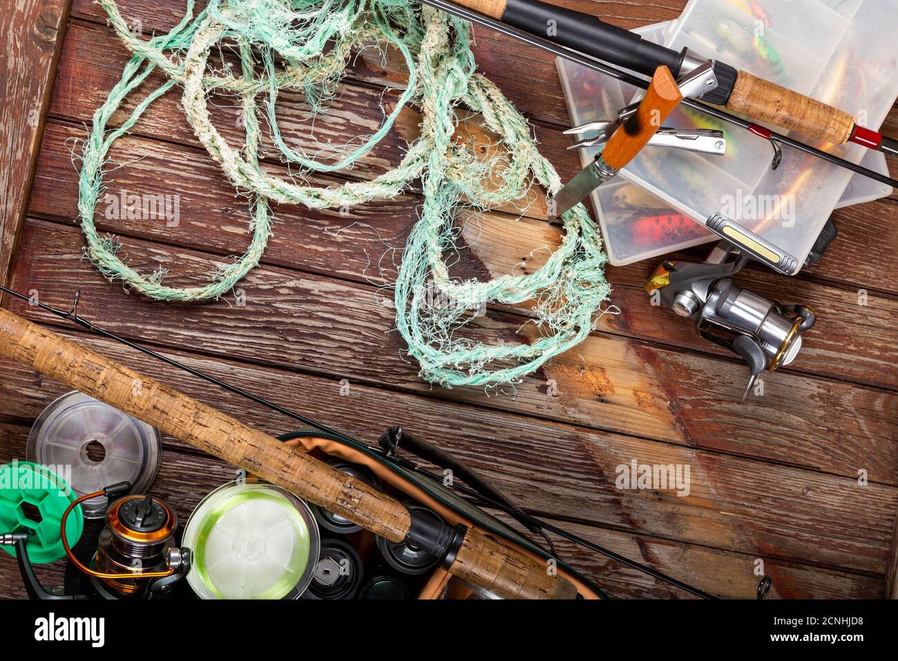 Verschiedene Angeltacles mit Rute und Rollen auf hölzernem braunem Hintergrund. Mockap für Werbung und Veröffentlichung. Stockfoto