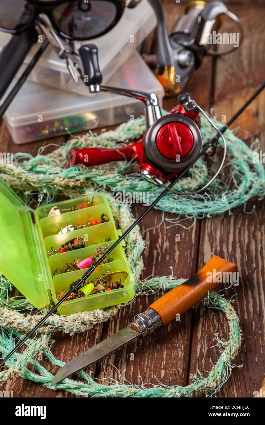 Verschiedene Angeltacles mit Rute und Rollen auf hölzernem braunem Hintergrund. Mockap für Werbung und Veröffentlichung. Stockfoto