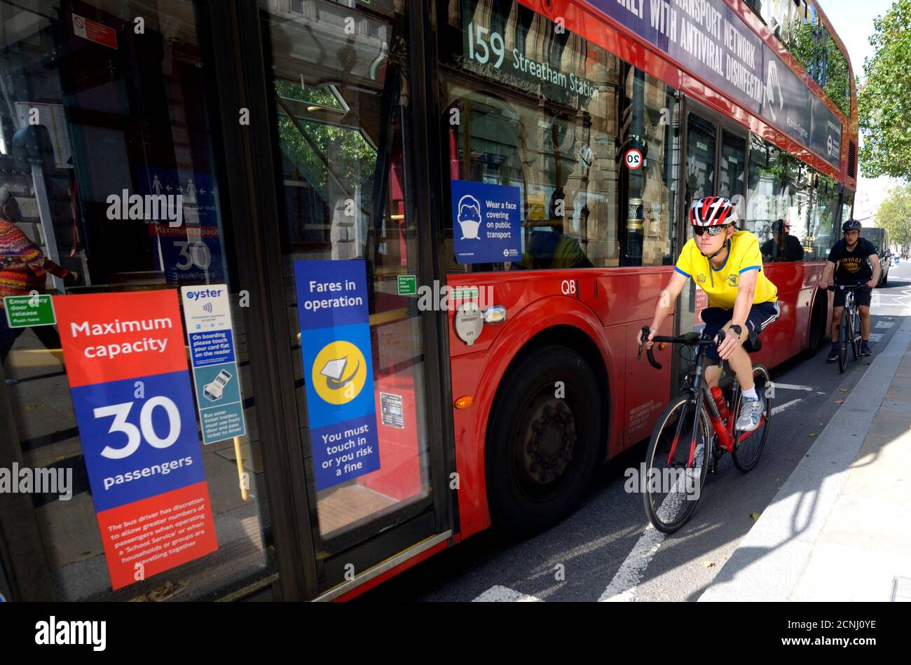 London, England, Großbritannien. Radfahrer, die einen Bus auf der Innenseite, Whitehall Stockfoto