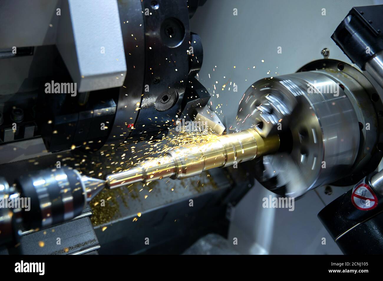 Metallindustrie für Werkzeugmaschinen. CNC-Drehmaschine High-Speed-Schneiden ist Operation.Flying Funken der Metallbearbeitung Stockfoto