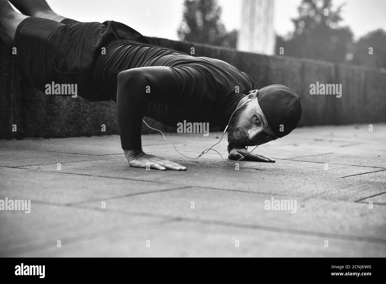 Gesundes Lifestyle-Konzept. Muskulöse Sportler trainieren Push-up draußen im Stadtpark. Stockfoto