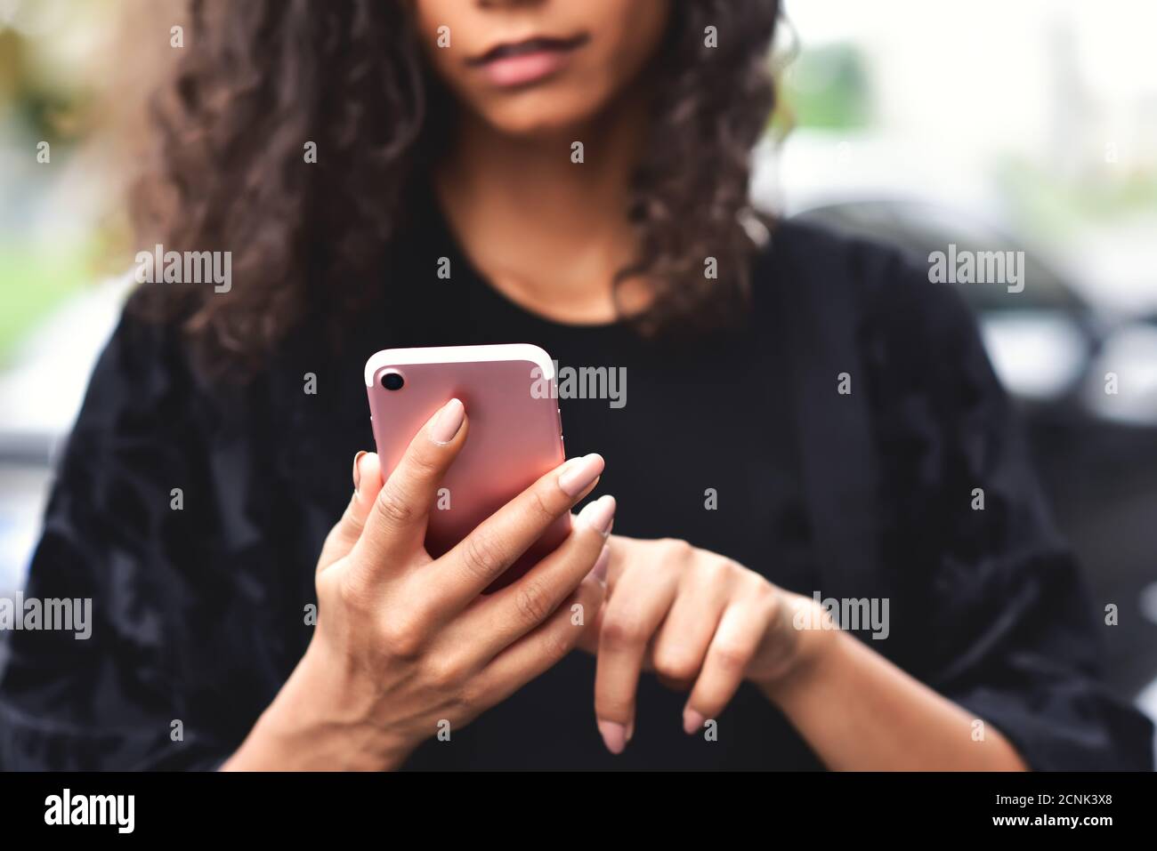 Nahaufnahme Bild einer schönen gemischten Rasse Frau halten, mit und Blick auf Smartphone mit Gefühl glücklich. Stockfoto