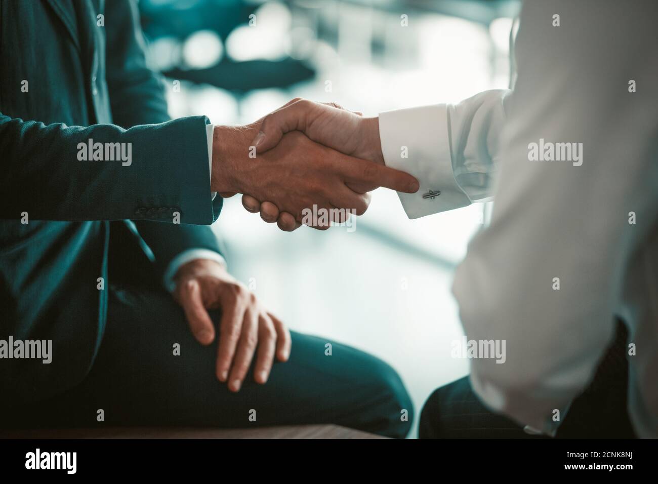 Mitarbeiter schütteln bei einem Geschäftstreffen die Hände. Ein Abkommen zwischen Partnern. Zwei Männer in Anzügen. Hochwertige Fotos Stockfoto