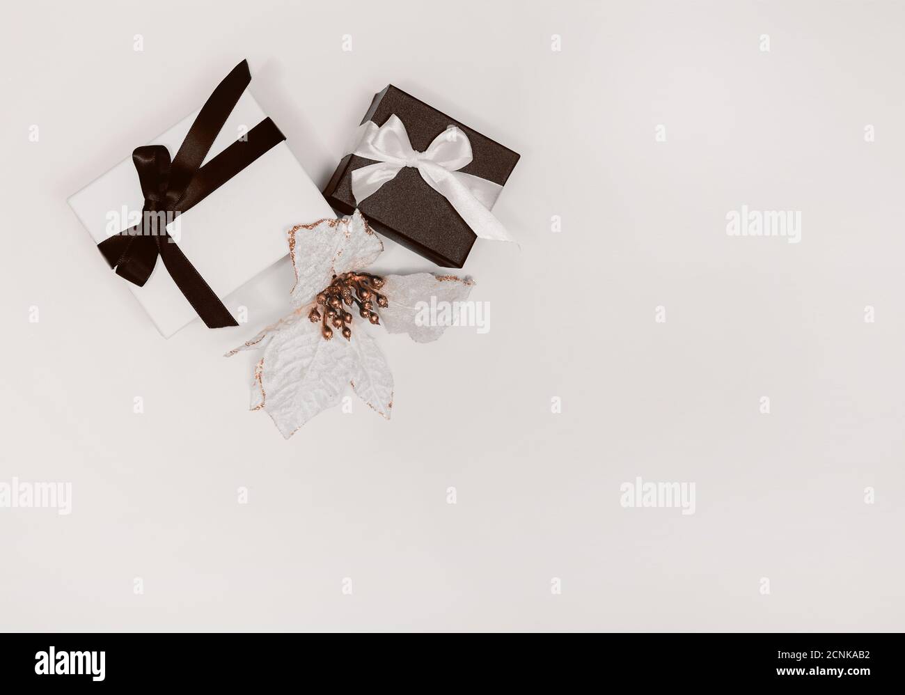 Schwarz und weiß Geschenk oder Geschenk-Boxen und Blume auf hellem Hintergrund. Flache Lay-Komposition für Geburtstag, Weihnachten, Hochzeit. Freier Speicherplatz für Text. Stockfoto