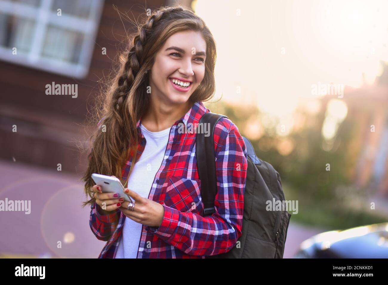 Foto von niedlichen Mädchen zu Fuß auf der Straße und mit einem Telefon Stockfoto