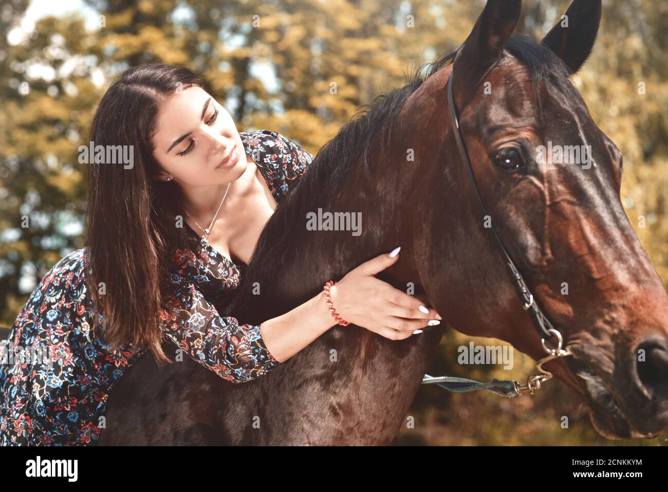 Ziemlich hispanische Brünette geben ihr Pferd eine Umarmung, während er im Wald reiten. Liebe Tiere Konzept. Liebe Pferde Stockfoto