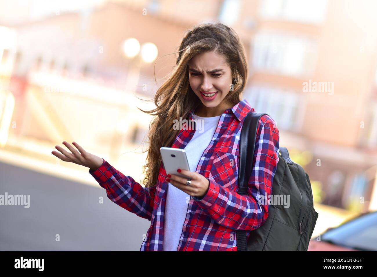 Foto von niedlichen Mädchen zu Fuß auf der Straße und mit einem Telefon Stockfoto