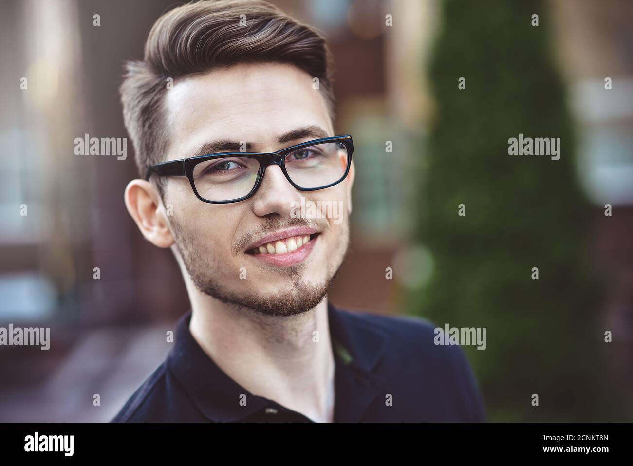 Junger netter Mann, der auf der Straße bleibt Stockfoto