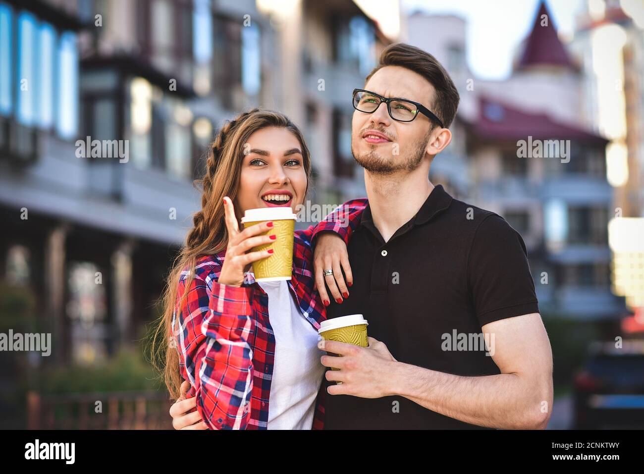 Tolles Paar, das auf der Straße läuft und einen Kaffee trinkt. Stockfoto