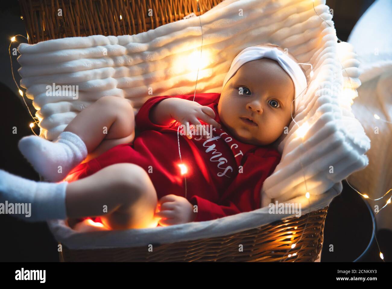 Neugeborenes Baby in einem roten schlafen in Flechten einen Korb. Stockfoto