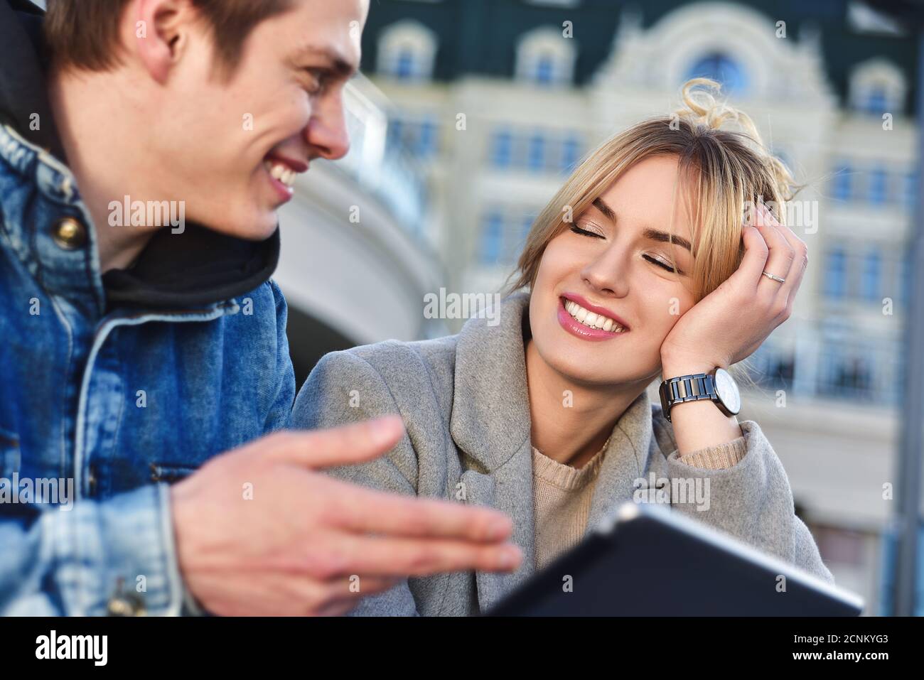 Glückliche Paare oder Freunde umarmen und Teilen einer Tablets auf der Straße Stockfoto
