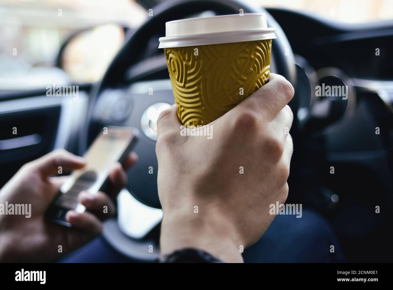 Mann halten Kaffee und fahren das Auto Stockfoto