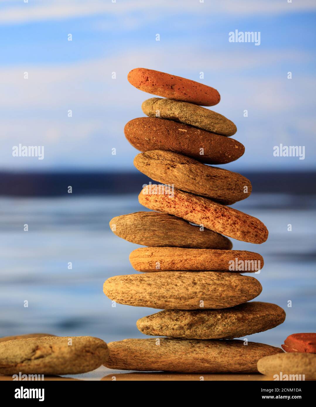 Harmonie, Gleichgewicht in der Natur. Zen-Steine stapeln sich auf blauem Himmel und Meer Hintergrund Stockfoto