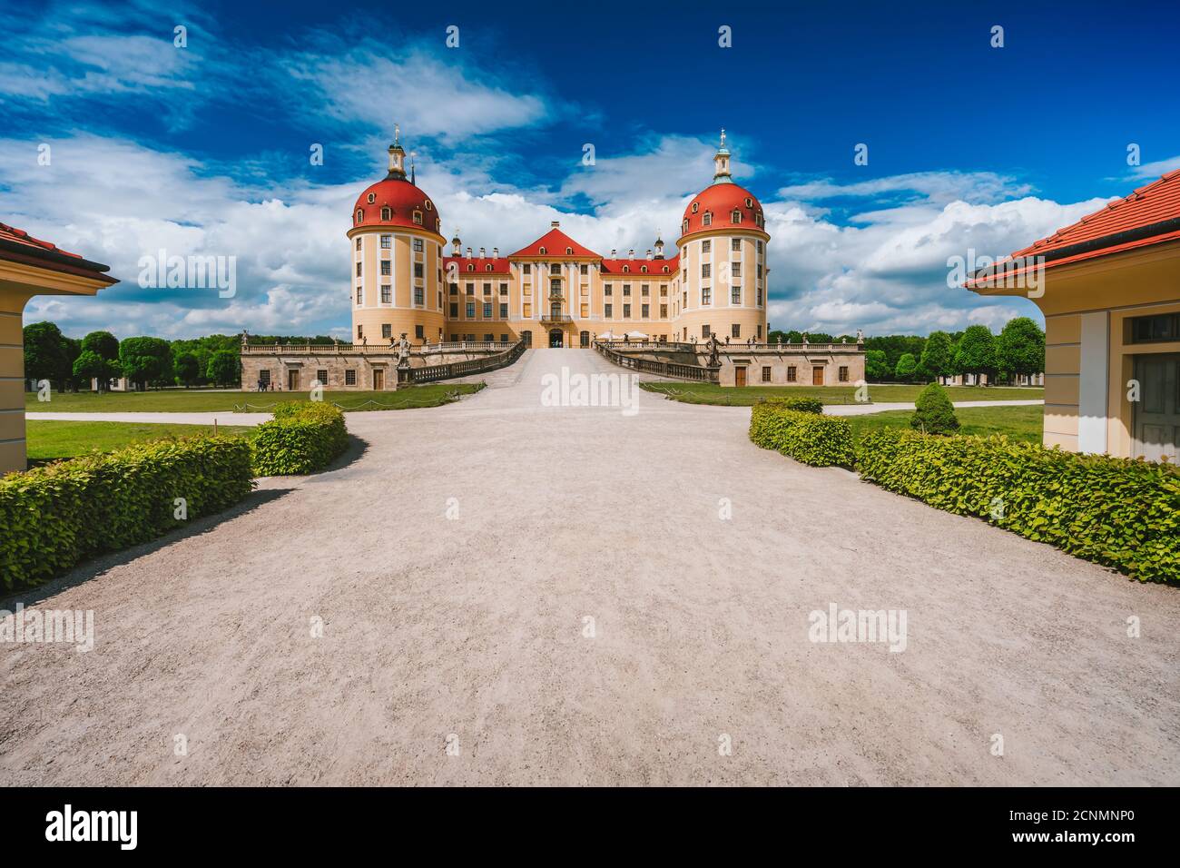 Deutschland, Sachsen Region, Dresden, Schloss Moritzburg. Schöner Frühlingstag mit blauem Himmel und weißen Wolken. Fußweg führt zu Schloss und Park. Stockfoto