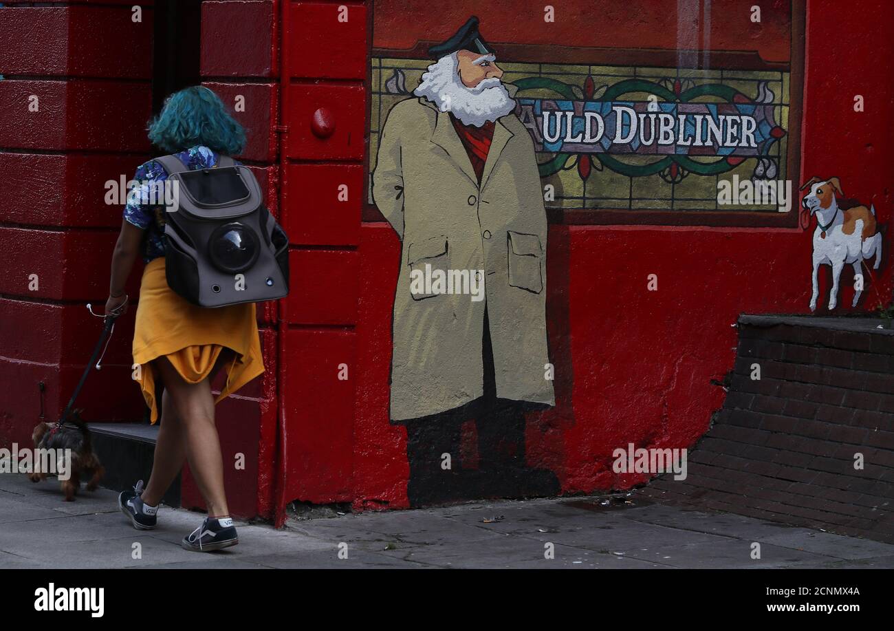 Eine Frau geht mit ihrem Hund am Auld Dubliner Pub in Dublins Temple Bar vorbei, da weitere Beschränkungen in Dublin voraussichtlich noch heute von der Regierung auferlegt werden. Unter Ebene 3 der Covid-Beschränkungen dürfen nur Restaurants und Pubs mit Außenanlagen geöffnet werden. Stockfoto
