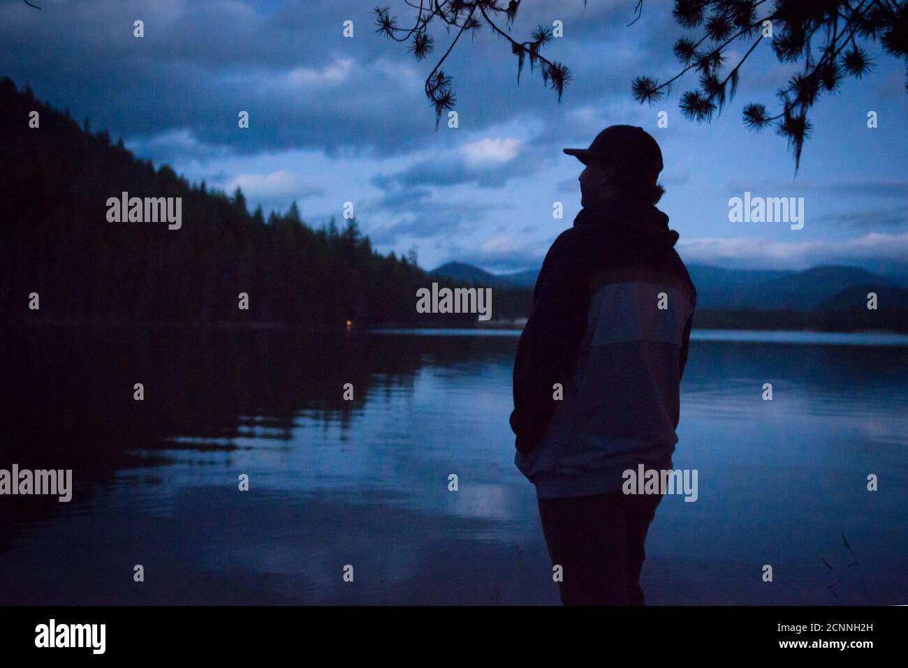 Silhouette eines Teenagers, der in der Abenddämmerung am Lemolo Lake, Umpqua National Forest, Oregon, USA, steht Stockfoto