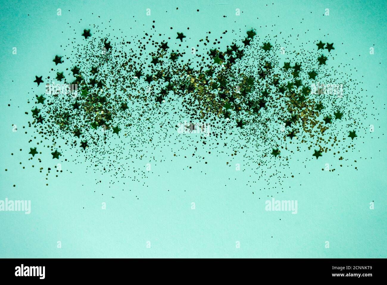 Gold Glitzer und Sterne auf türkisfarbenem Hintergrund Stockfoto