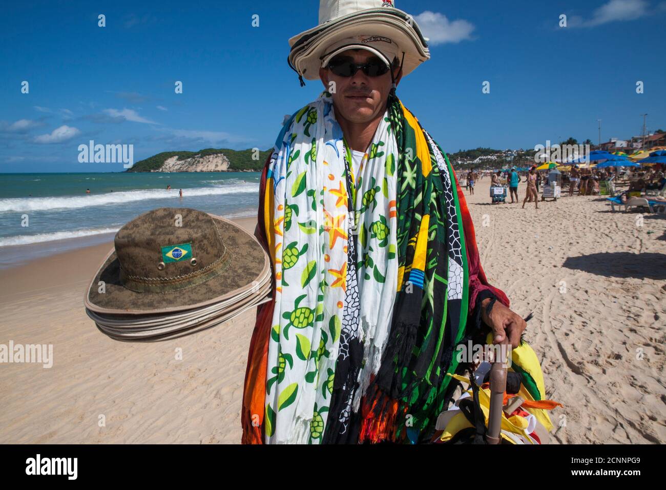Straßenverkäufer verkauft Hüte und kangas (Kleidung) am Ponta Negra Strand, Natal Stadt, Rio Grande do Norte Staat, Nordostbrasilien. Stockfoto