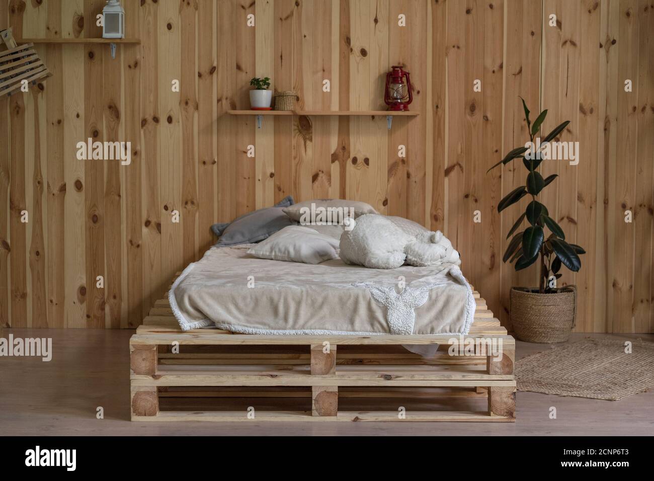 Holzbett in minimalem Stil. Startseite Holz Interieur mit Licht Leinen und Vase oder Bücherregale. Hochwertige Fotos Stockfoto
