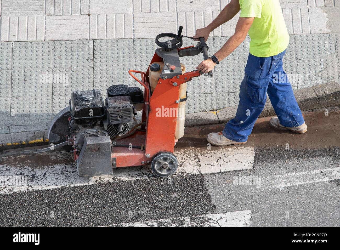 Bauarbeiter Schneiden Betonboden mit Diamant-Sägeblatt-Maschine Auf einem Bürgersteig Stockfoto
