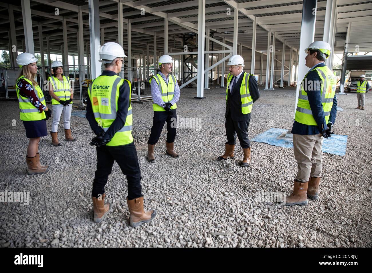 Premierminister Boris Johnson stößt mit Bauarbeitern auf die Ellbogen, als er die Baustelle des neuen Vaccines Manufacturing and Innovation Center (VMIC) besucht, das derzeit auf dem Harwell Science and Innovations Campus in der Nähe von Didcot gebaut wird. Das Gebäude wird für die Herstellung von Impfstoffen für Covid-19 gebaut und soll im nächsten Sommer eröffnet werden. Stockfoto