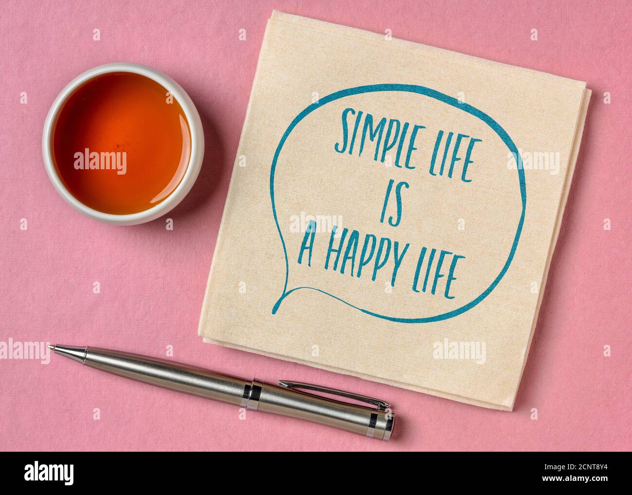Einfaches Leben ist ein glückliches Leben inspirierende Zitat - Handschrift auf einer Serviette mit einer Tasse Tee, Glück, Erfolg und persönliche Entwicklung Konzept Stockfoto