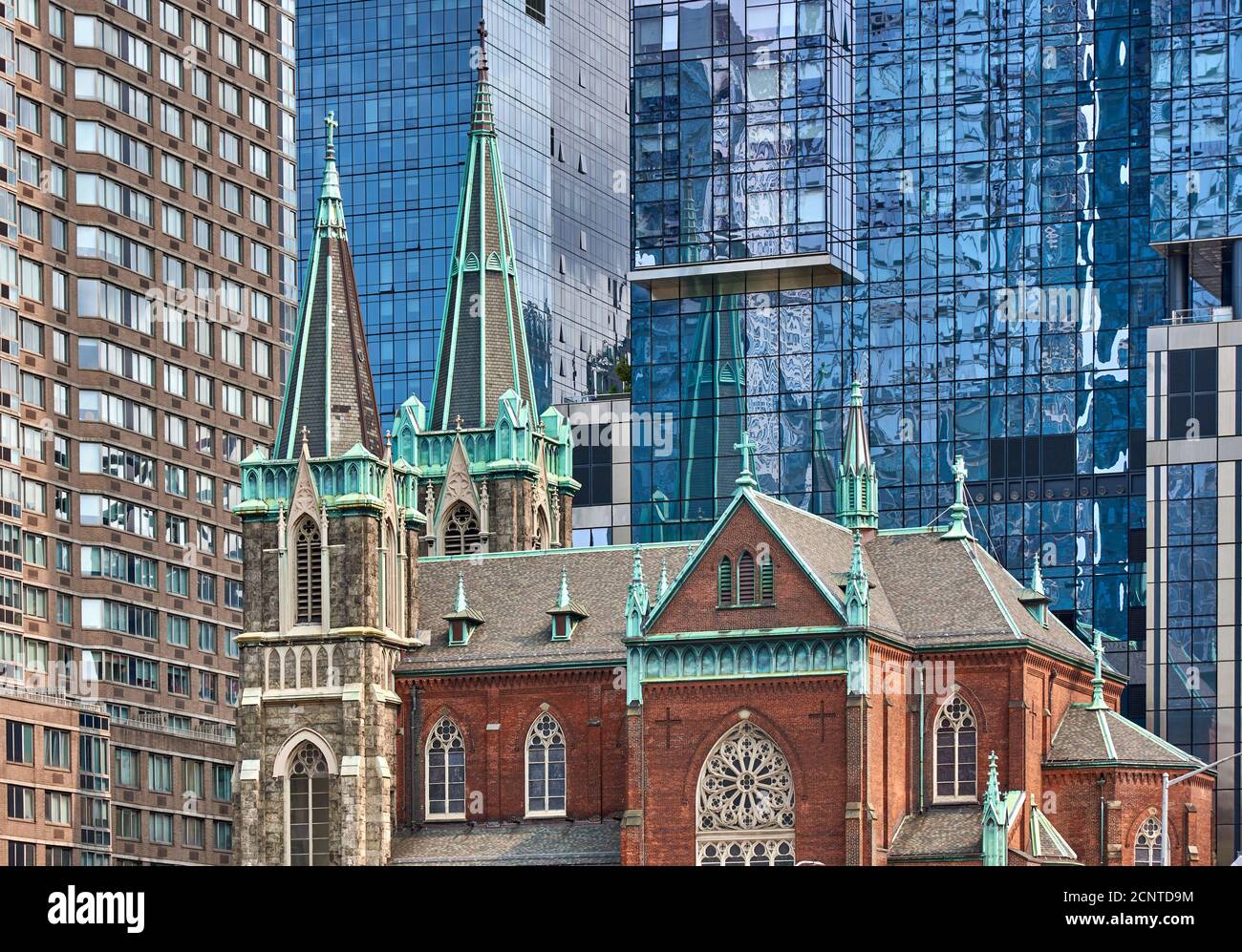 Eine Kirche ist von Glas und Backstein Wolkenkratzern umgeben, die römisch-katholische Kirche St. Cyril & Methodius und St. Raphael Stockfoto