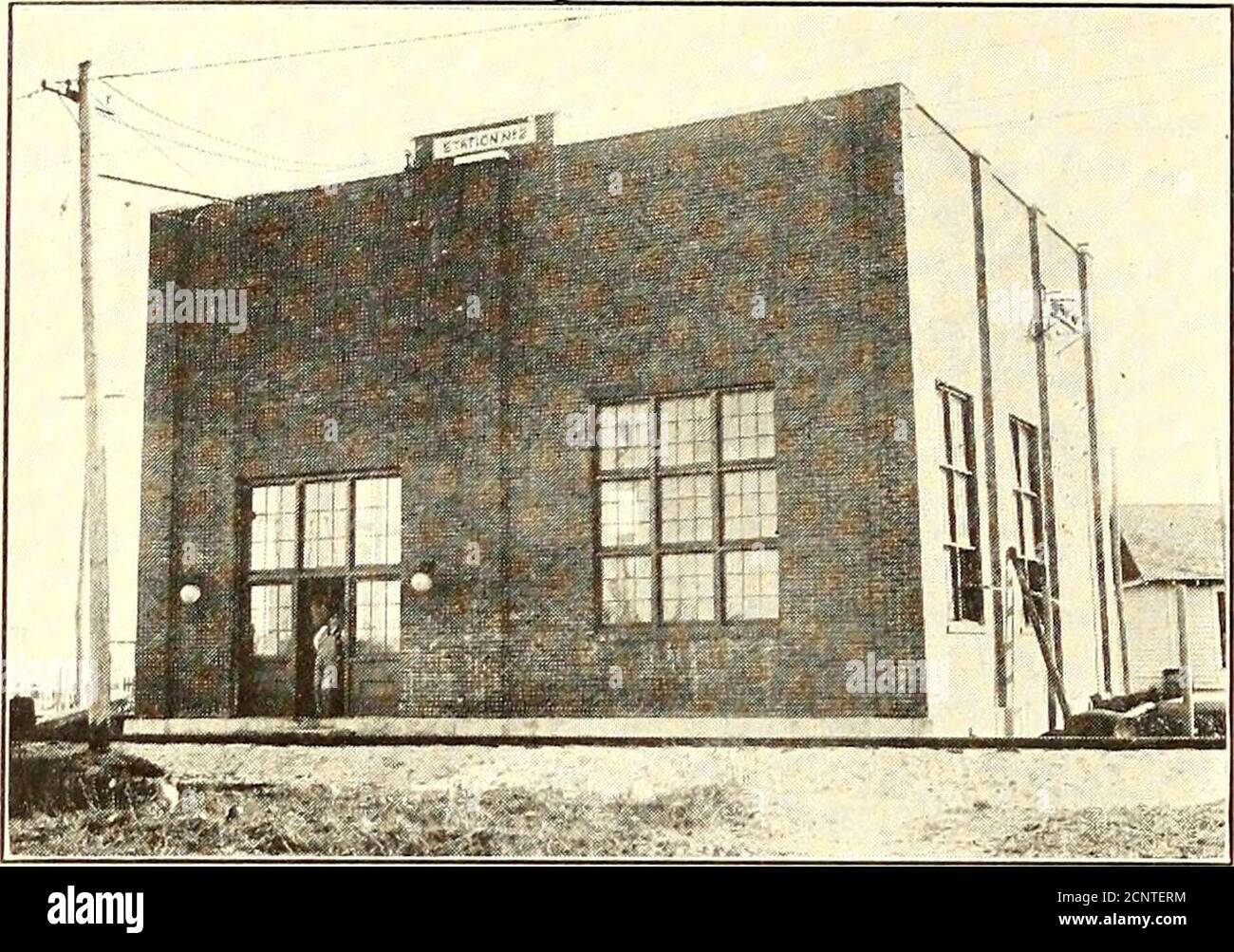 . Elektrische Eisenbahn Zeitschrift . ANSICHT ZEIGT FRACHTGLEISE UND OVERHEAD.BEACHTEN SIE DEN RIESIGEN CHAT-STAPEL RECHTS EINE TYPISCHE MINE, BEI PICHER, MIT DEN NUMEROUSONE-GESCHOSS BERGLEUTE IN DER FERNE 844 ELECTRIC RAILWAY JOURNAL VOL. 57, NO. 19. AUSSERHALB DES UMSPANNWERKS NR. 2 – IN PICHER – WIRD demnächst ein anderes IN BETRIEB genommen. Der eine Betrieb befindet sich in Picher und enthält eine 400-kw-leistung. G.E.Wandler, gespeist von drei 145 kw. Allgemeine elektrische Transformatoren. Das andere Umspannwerk, das sich in Commerce befindet, enthält zwei 400 kw. General Electric Konverter und wird mit drei 250-kw ausgestattet. Neu Stockfoto