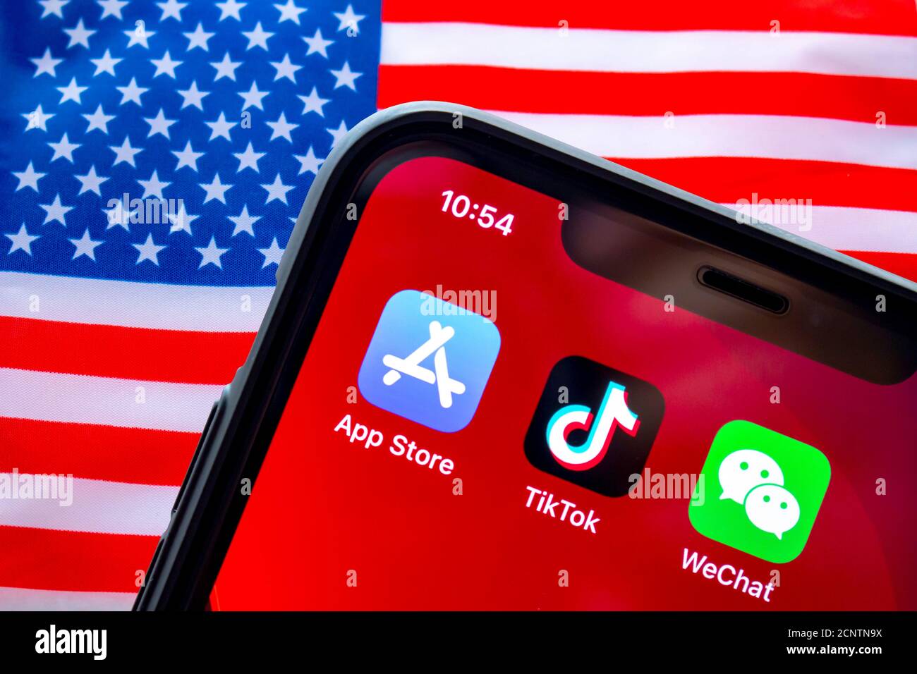 Calgary, Alberta, Kanada. September 18 2020. Ein iPhone mit dem App Store, TikTok und WeChat Anwendungen mit einer USA Flagge im Hintergrund. Stockfoto
