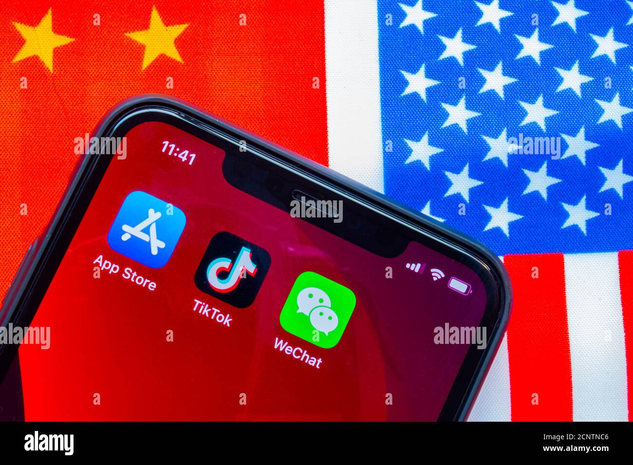 Calgary, Alberta, Kanada. September 18 2020. Ein iPhone mit dem App Store, TikTok und WeChat Anwendungen mit einer USA und China Flagge im Hintergrund. Konz Stockfoto