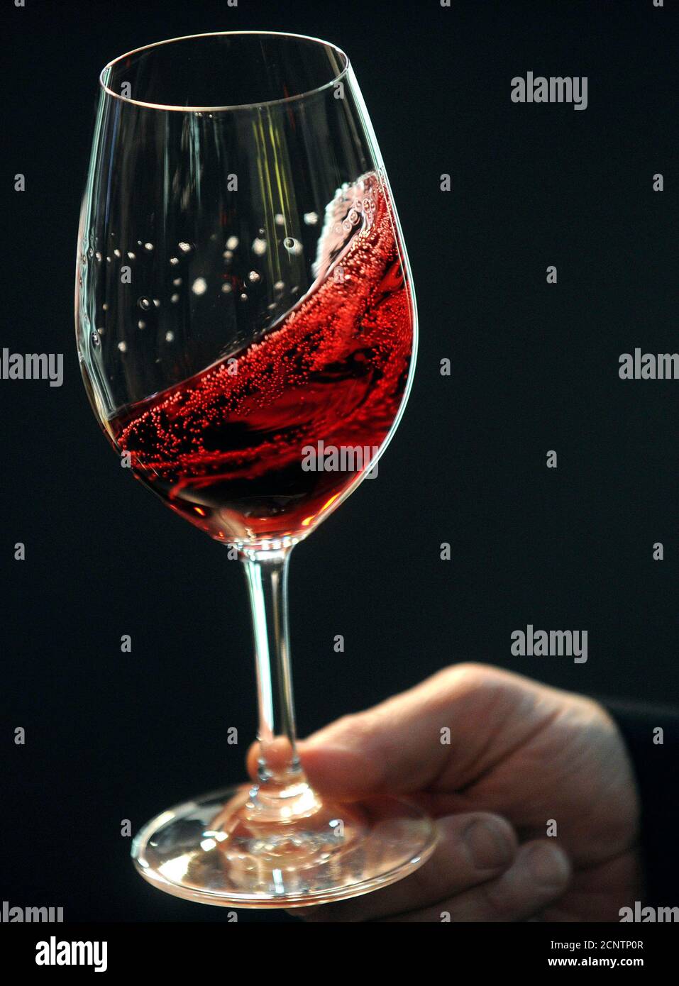 Ein Mann hält ein Glas Rotwein auf der Vinitaly Wein-Expo in Verona 8.  April 2010. Italien, die weltweit zweitgrößte Weinproduzent nach  Frankreich, hatte von ca. 4,5 Milliarden Liter (989,9 Millionen Imp  Gallonen)