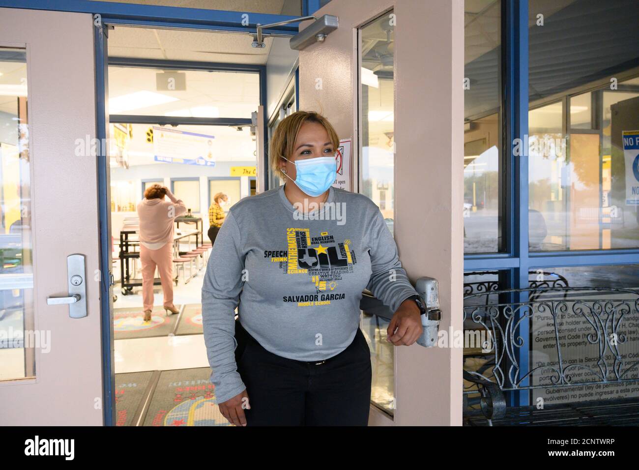 Rio Bravo, Texas, USA. September 2020. Die stellvertretende Schulleiterin JOANNA NAVARRO schaut während eines seltenen Regensturms auf den Haupteingang der Salvador Garcia Mittelschule in Colonia' Rio Bravo bei Laredo entlang der texanischen Grenze zu Mexiko. Navarro hilft, sich auf den Beginn des persönlichen Unterrichts nächste Woche vorzubereiten. Quelle: Bob Daemmrich/ZUMA Wire/Alamy Live News Stockfoto