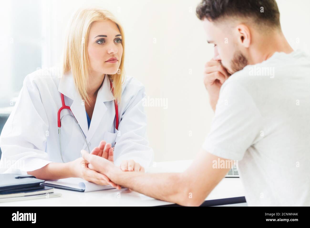 Frau Doktor ist im Gespräch und die Untersuchung der männlichen Patienten im Krankenhaus. Gesundheitswesen und medizinische Betreuung. Stockfoto