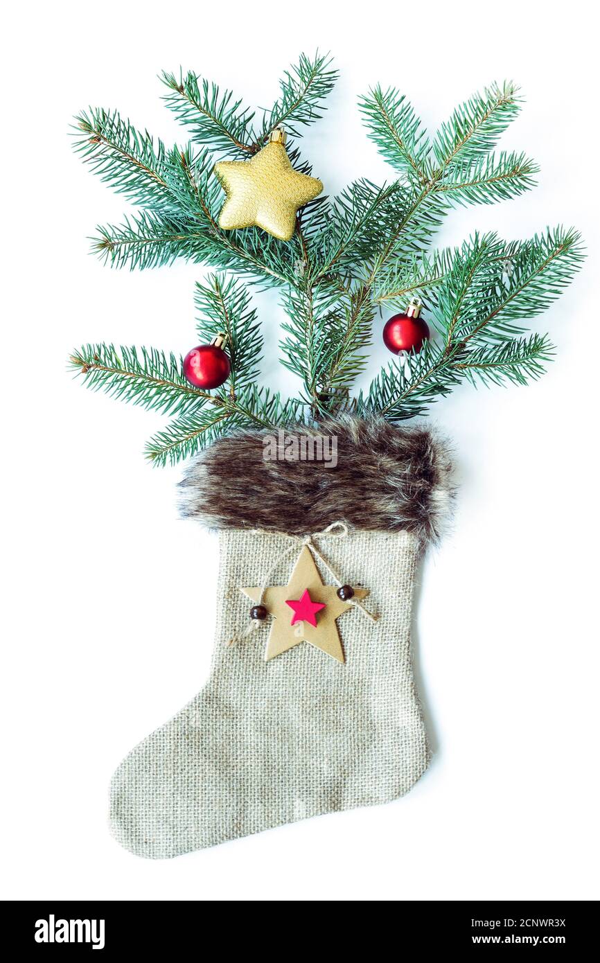 Weihnachtsbaum und Spielzeug in weihnachtssocke aus Sacktuch auf weißem Hintergrund. Flach liegend, Draufsicht. Stockfoto