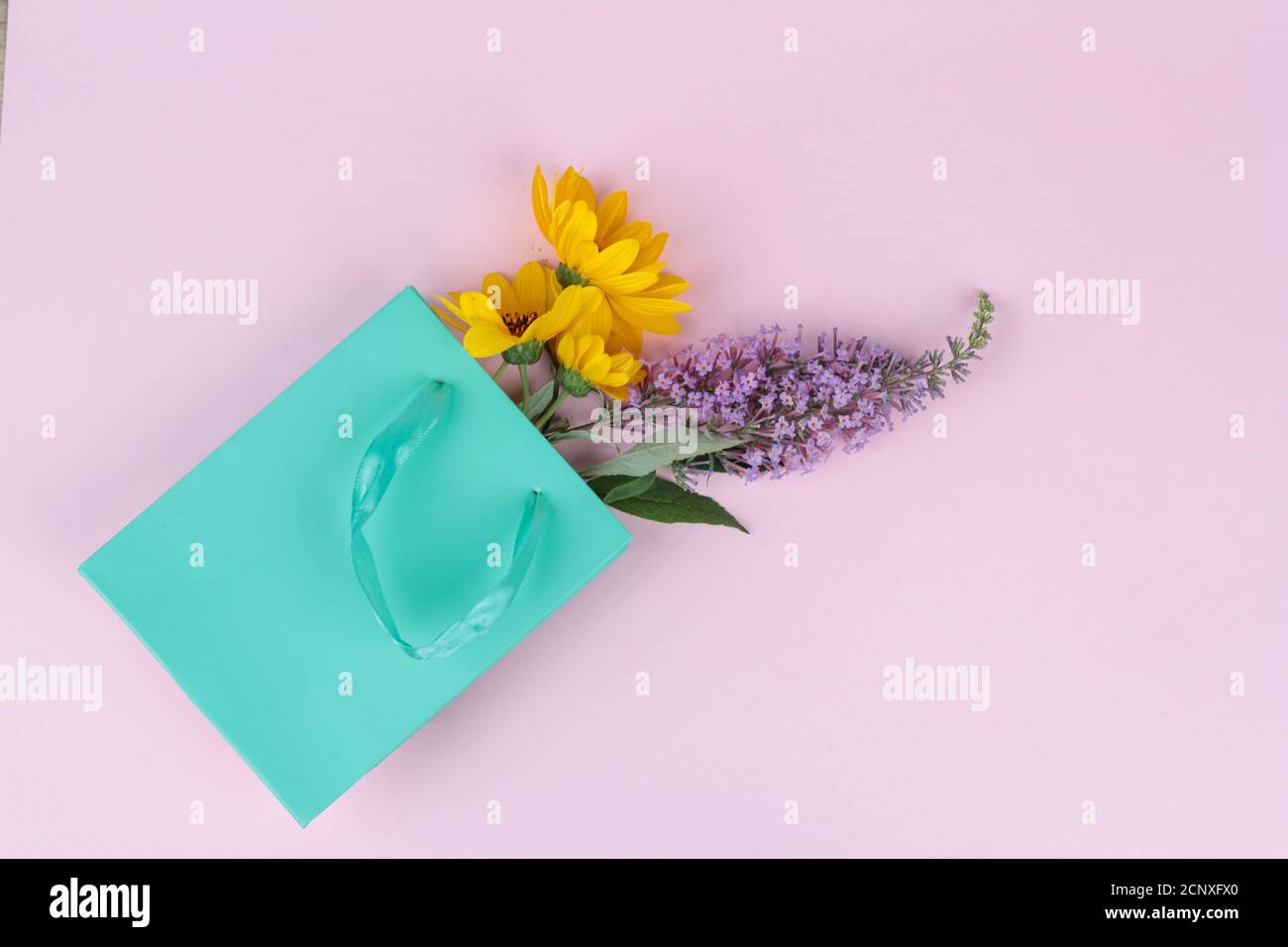 Wilde Blumen, gelb und lila in einer Geschenktüte, Grußkonzept, Geschenk. Platz für Text Stockfoto