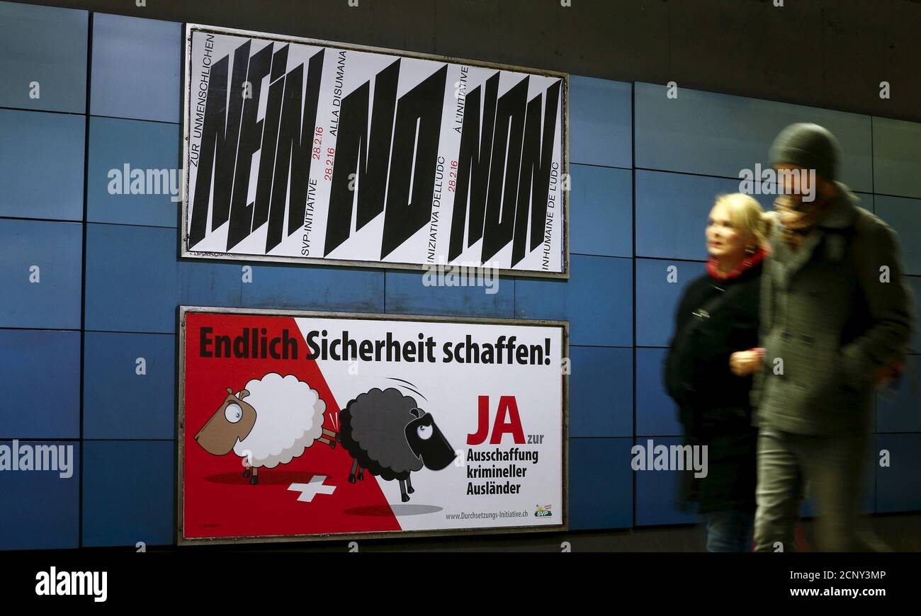 Ein Plakat der Schweizerischen Volkspartei (SVP), das fordert, für eine  Initiative zur Ausweitung krimineller Ausländer zu stimmen, wird unter  einem anderen Plakat gegen sie am Hauptbahnhof in Zürich, Schweiz, 12.  Februar 2016