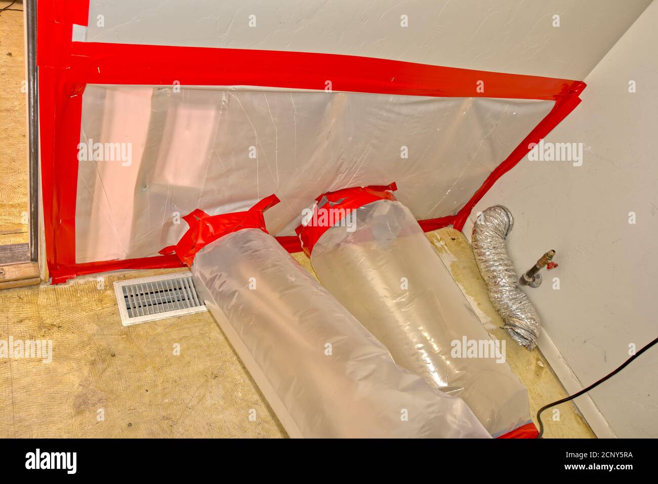 Eine Wand, die durch eine Flut beschädigt wurde, die ausgetrocknet wurde, indem sie Luft in die Hohlabschnitte der Wand zwang. Stockfoto