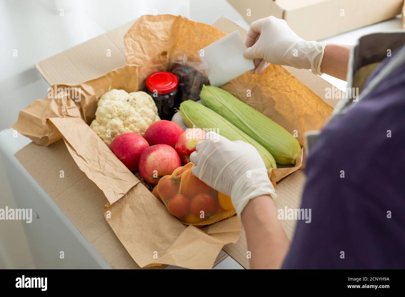 Ein Freiwilliger packt Essen in eine Sozialhilfe-Box. Spende. Stockfoto