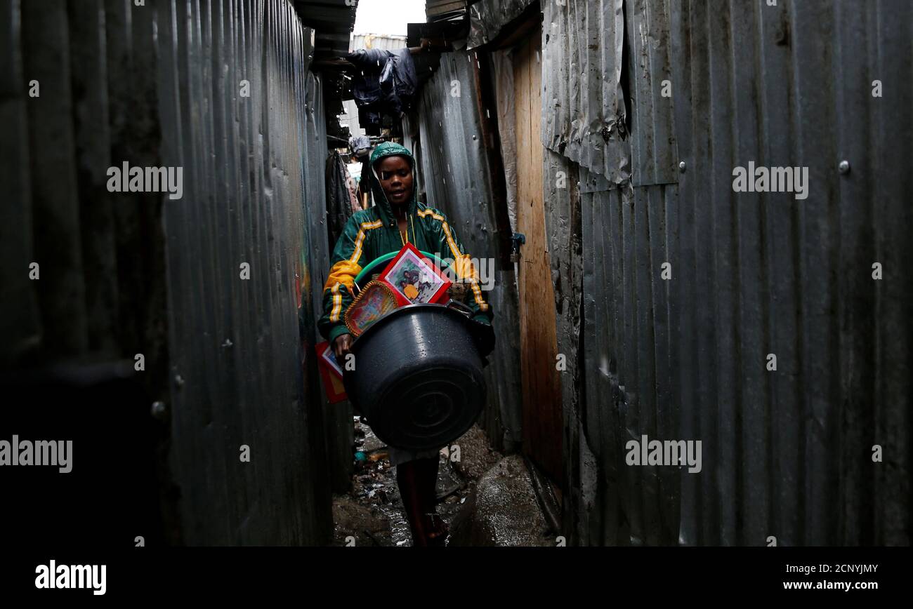 Eine Frau trägt ihr Eigentum, als sie das Huruma-Viertel nach einem sechsstöckigen Gebäudeeinsturz nach Tagen heftigen Regens in Nairobi, Kenia, am 1. Mai 2016 verlässt. REUTERS/Thomas Mukoya TPX-BILDER DES TAGES Stockfoto