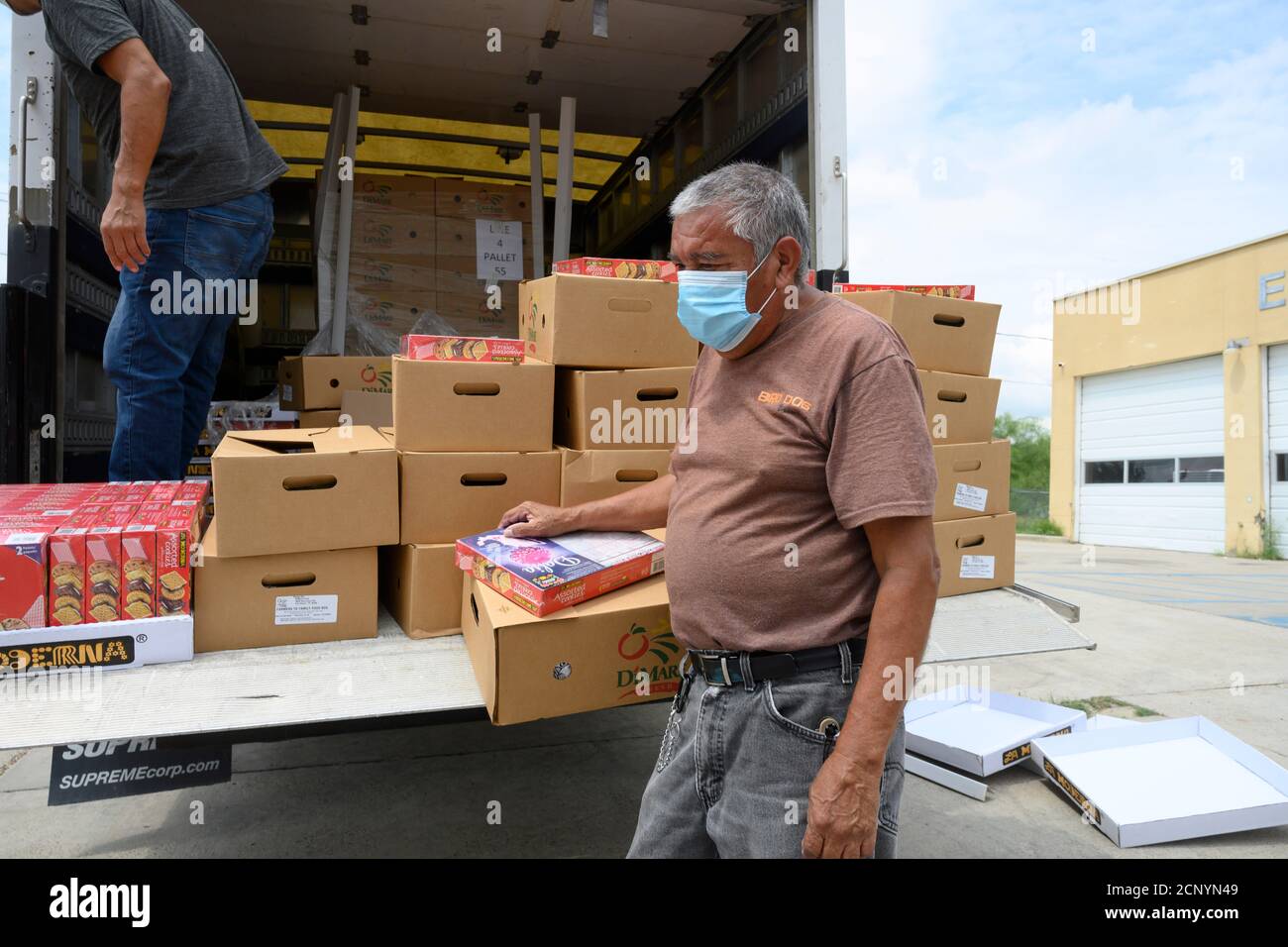 El Cenizo, TX USA 17. September 2020: Lokale Freiwillige verteilen Lebensmittelkisten an Bewohner der colonia von El Cenizo etwa 10 Meilen südlich von Laredo entlang der Texas-Mexiko-Grenze. Etwa 450 Familien werden zweimal in der Woche mit Heftklammern und frischem Obst in einer von der lateinamerikanischen lutherischen Mission (LALM) gesponserten Bemühung serviert. Aufgrund der Coronavirus-Pandemie ist die Verteilung nun ein sozial distanziertes Drive-Through-Ereignis, bei dem Freiwillige und Kunden alle Gesichtsbezüge tragen. Kredit: Bob Daemmrich/Alamy Live Nachrichten Stockfoto