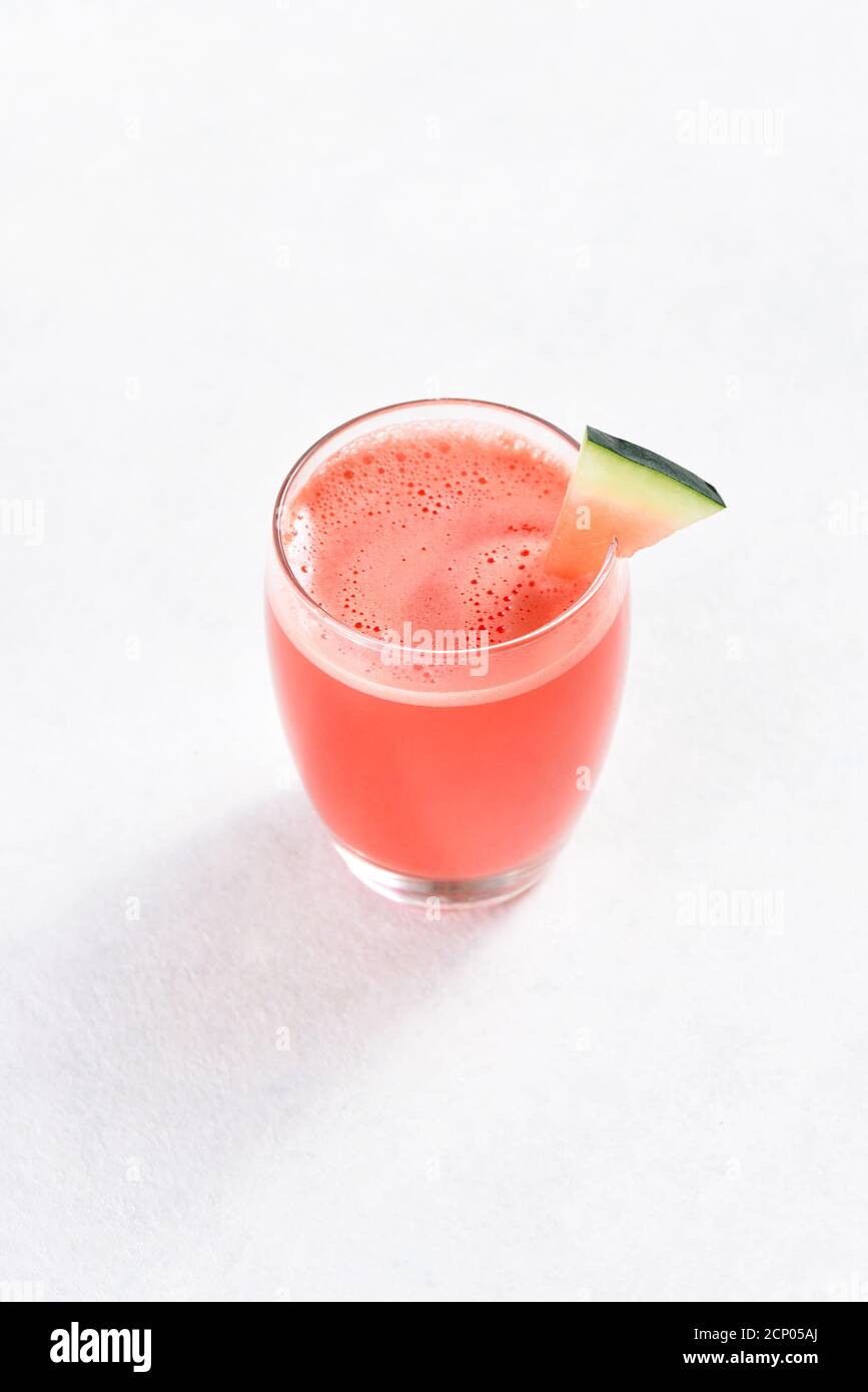 Wassermelone Saft in einem Glas auf weißem Stein Backgrond mit freiem Text Raum. Gesundes Sommergetränk. Stockfoto