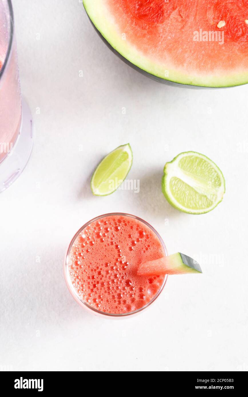 Wassermelone Saft in einem Glas auf weißem Stein Hintergrund. Gesundes Sommergetränk. Draufsicht, flach liegend Stockfoto