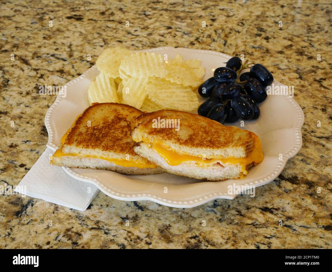 Gegrilltes Käse-Sandwich auf Teller mit Seiten. Stockfoto