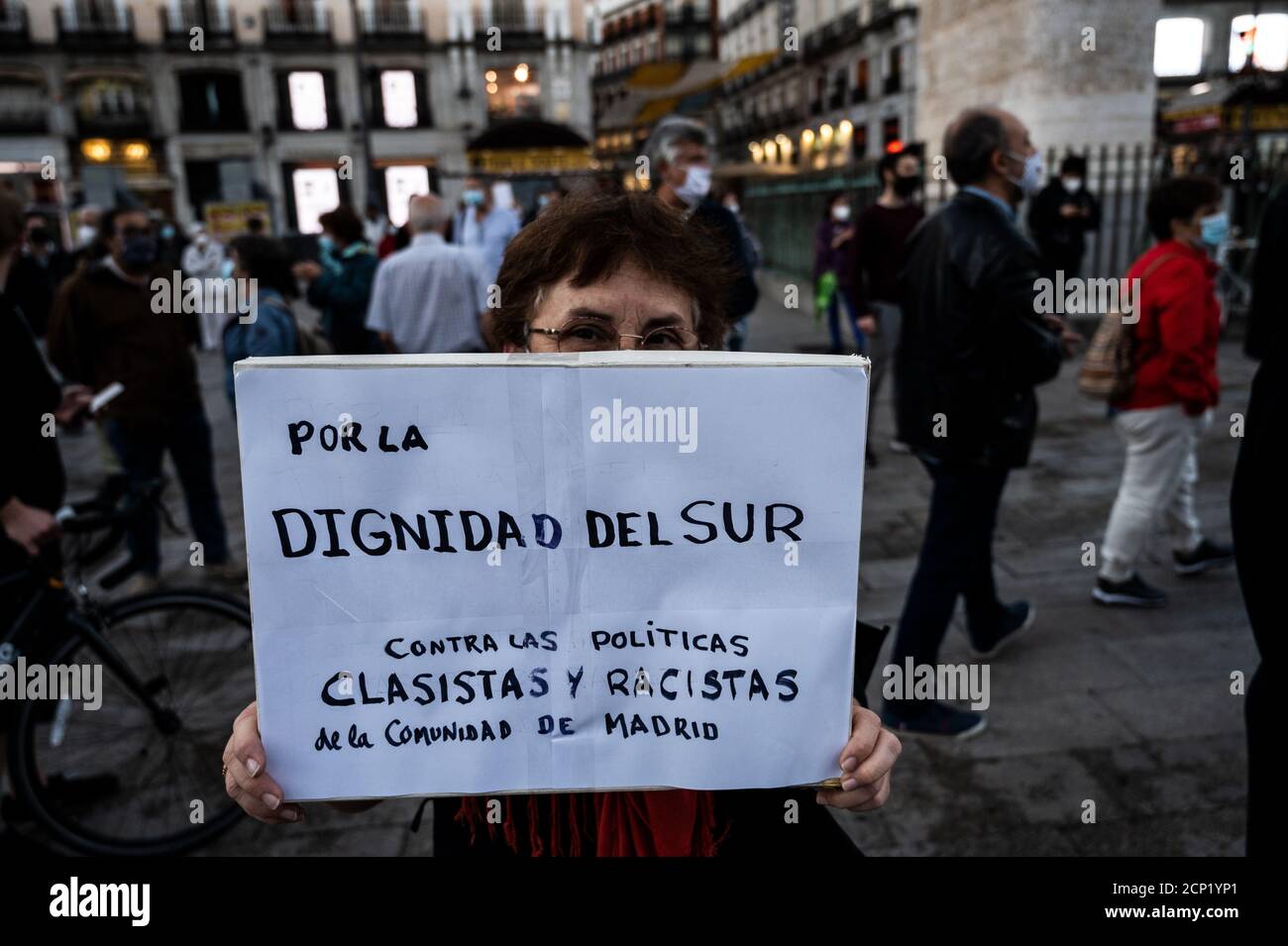 Madrid, Spanien. September 2020. Eine Frau hält ein Plakat mit der Aufschrift "für die würde des Südens, gegen die klassizistische und rassistische Politik der Gemeinschaft Madrid". Auf dem Sol-Platz haben sich Menschen versammelt, um gegen die letzten Restriktionsmaßnahmen zu protestieren, die am kommenden Montag als Regionalpräsidentin der Gemeinschaft Madrid angewendet werden sollen. Isabel Diaz Ayuso kündigte heute an, die Ausbreitung des Coronavirus zu stoppen. Zu den Beschränkungsmaßnahmen gehören Mobilitätseinschränkungen in einigen Stadtteilen. Quelle: Marcos del Mazo/Alamy Live News Stockfoto